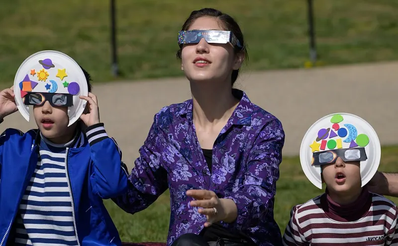 People watching a solar eclipse wearing certified eclipse glasses